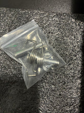 Load image into Gallery viewer, A small clear plastic bag containing several silver metal hardware pieces, including a coiled spring and small hooks, placed on a textured dark gray surface.
