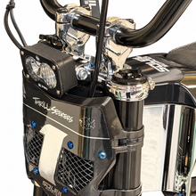 Load image into Gallery viewer, Close-up of a black and chrome electric scooter or motorcycle front end, featuring a dual LED headlight, black handlebars, a black front fender with white 'Thrill Seekers' graphics, and shiny chrome fork and cowl details.