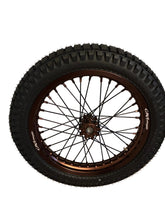 Load image into Gallery viewer, A custom off-road bicycle wheel with a black knobby tire, bronze-colored rim, and thin black spokes, leaning against a beige wall on a tiled floor.
